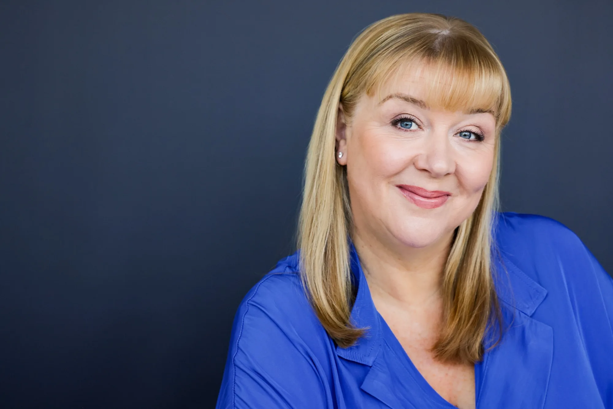Heidi Lance smiling at the camera in a cobalt-blue shirt